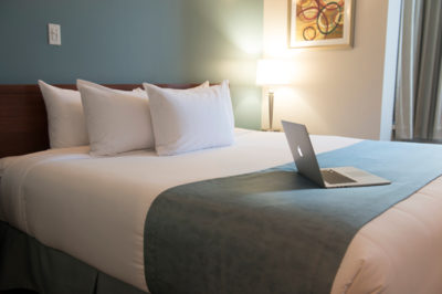 Apple laptop on queen sized bed